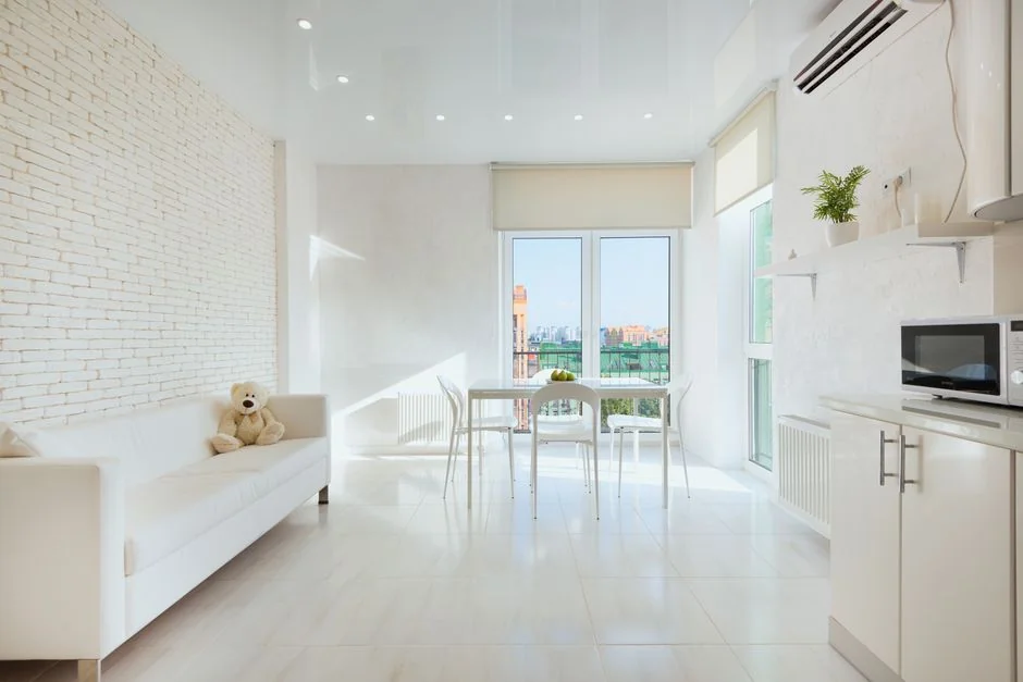 A hotel housekeeper carefully piles fresh towels in a refined room setting.
