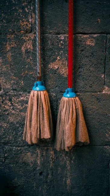 Une gouvernante professionnelle tenant une pile de serviettes fraîches dans une chambre d'hôtel luxueuse, illustrant l'élégance et la qualité du service.